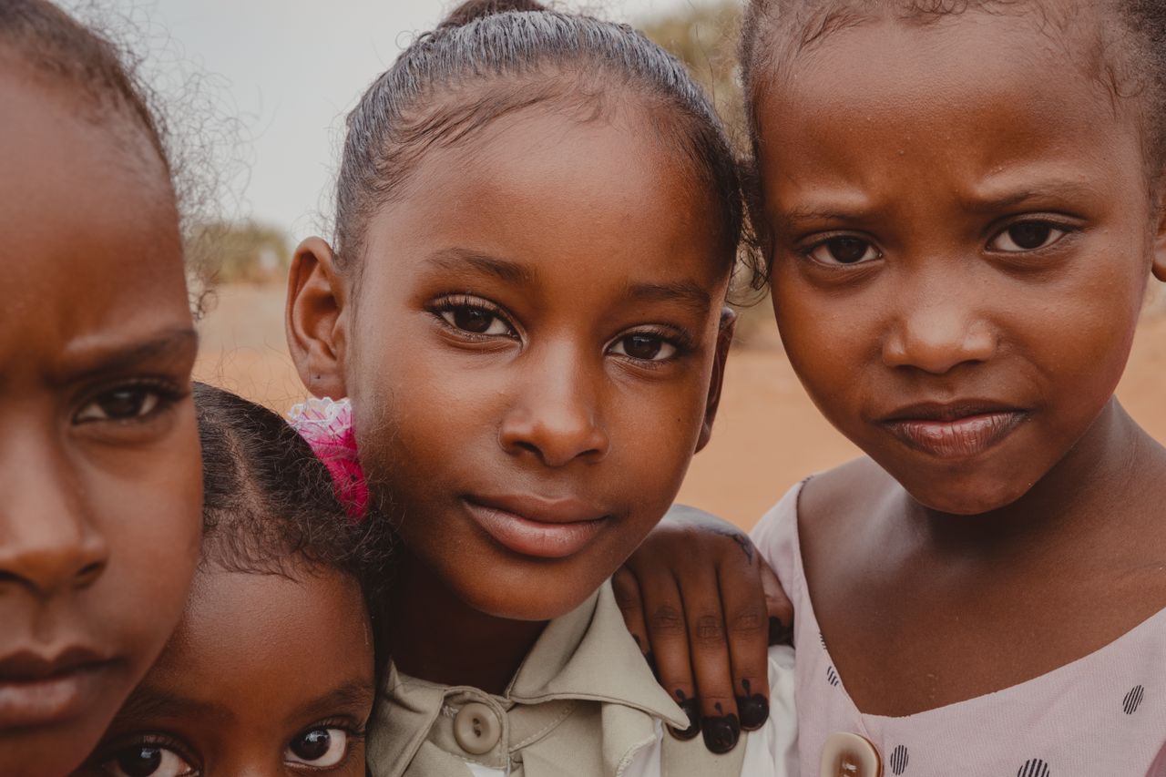 Close-up portrait of four young girls together outdoors, showcasing friendship.